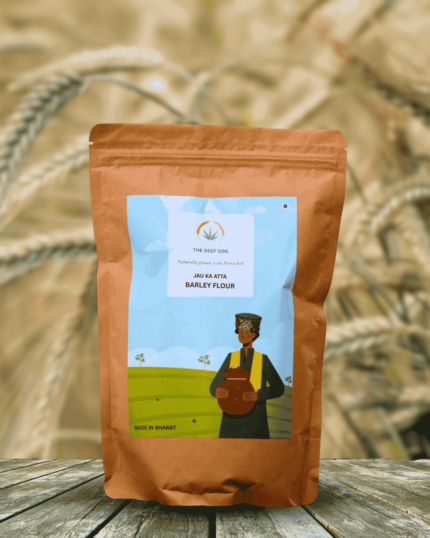 The Deep Soil Barley Flour Jau Ka Atta package on wooden table with sunlit barley field background