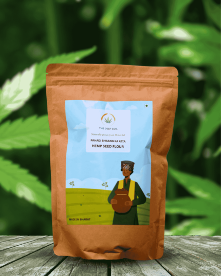 The Deep Soil Hemp Seed Flour Pahadi Bhaang Ka Atta package on wooden table with green hemp leaves background