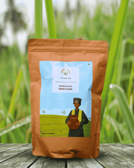 The Deep Soil Kodo Flour Kodra Ka Atta package on wooden table with green kodo millet field background