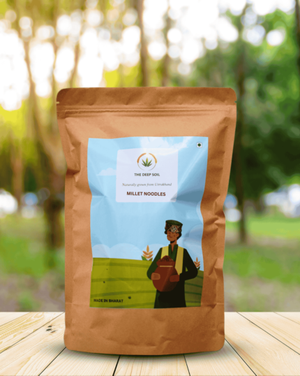 The Deep Soil Millet Noodles package on wooden table with sunlit forest park background