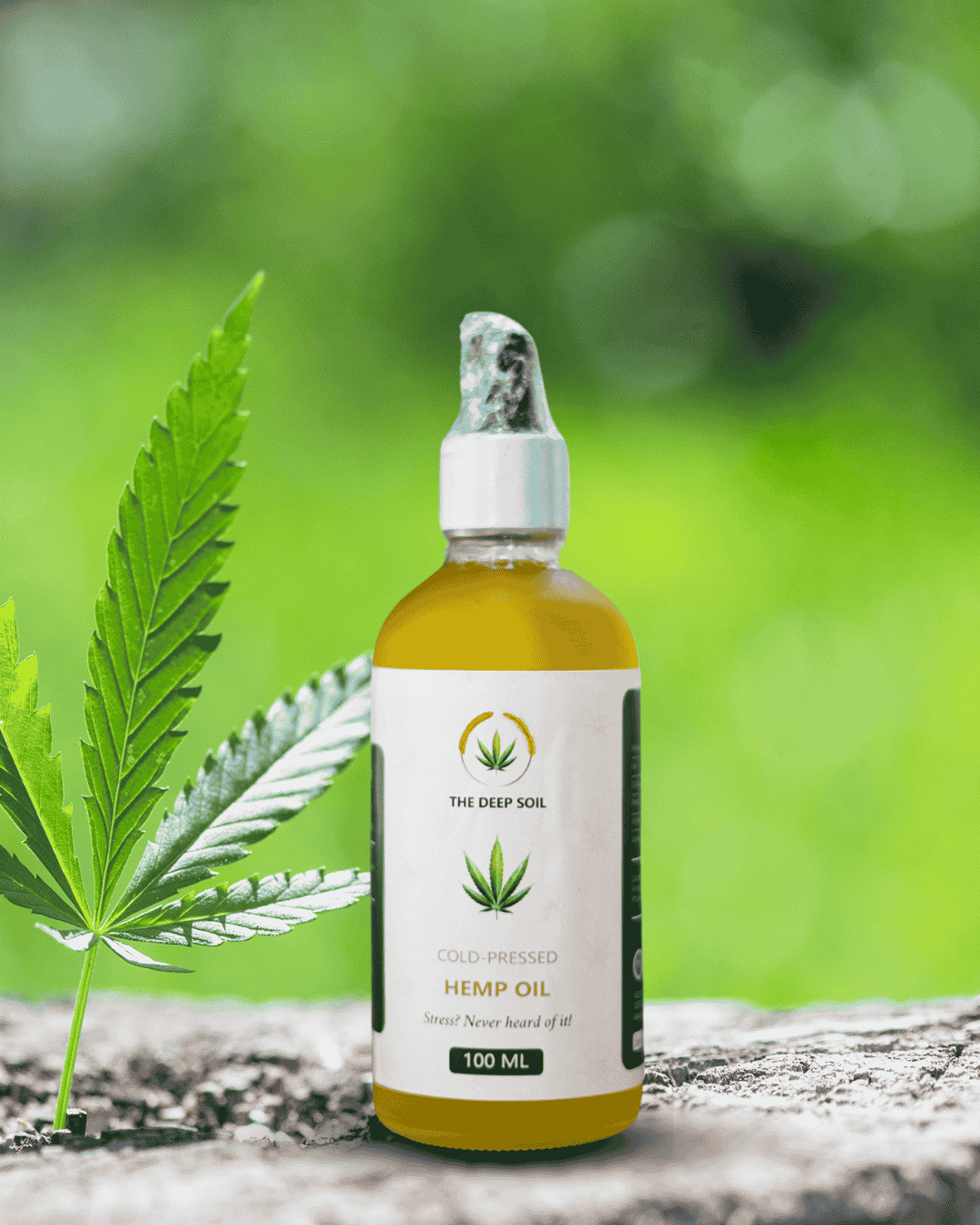 The Deep Soil Cold-Pressed Hemp Oil 100ML Wellness Dropper Bottle The Deep Soil Cold-Pressed Hemp Oil 100ml dropper bottle with a fresh green hemp leaf and blurred forest background