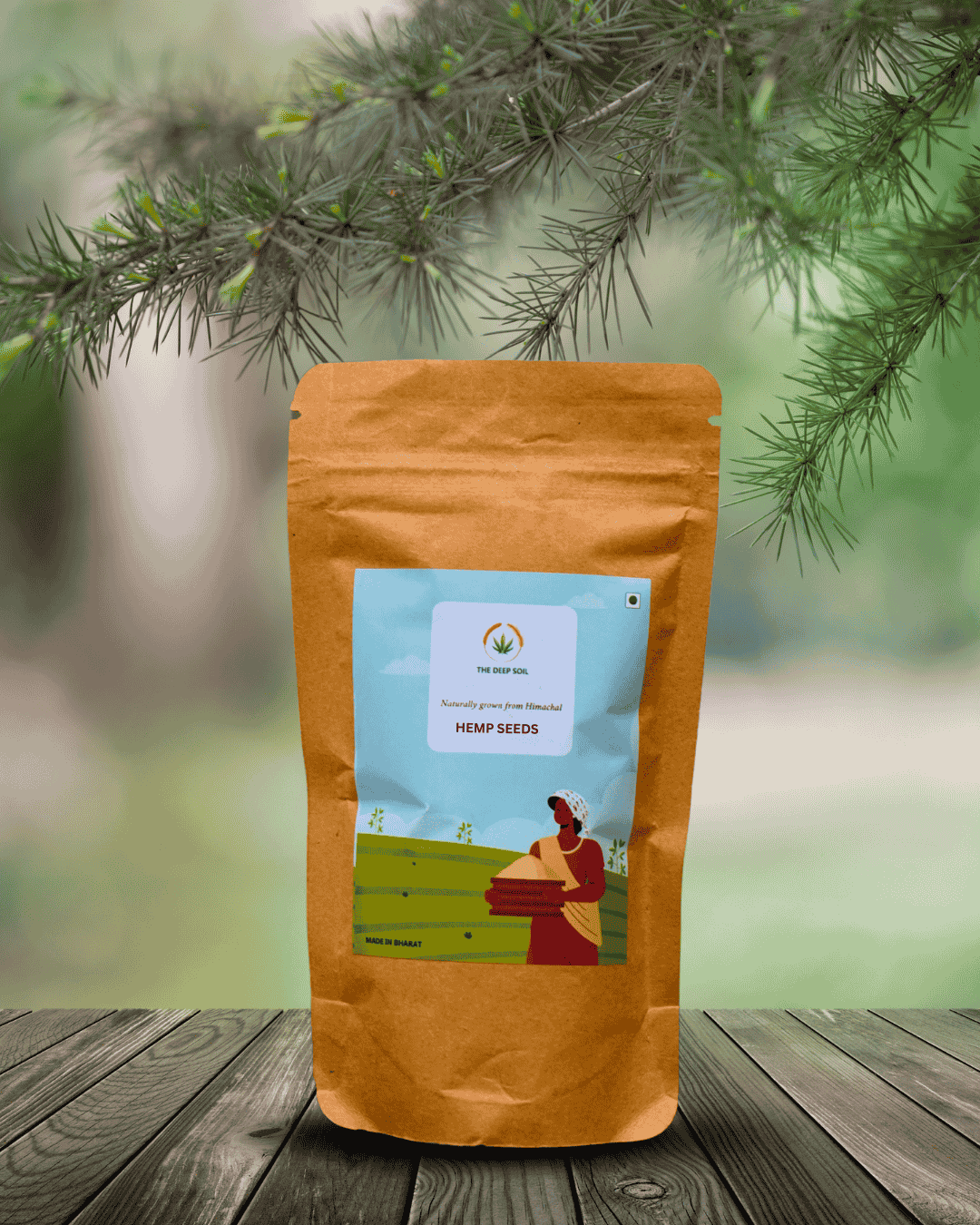 The Deep Soil Natural Hemp Seeds From Himachal The Deep Soil Hemp Seeds brown paper package on a wooden table with pine tree branches background