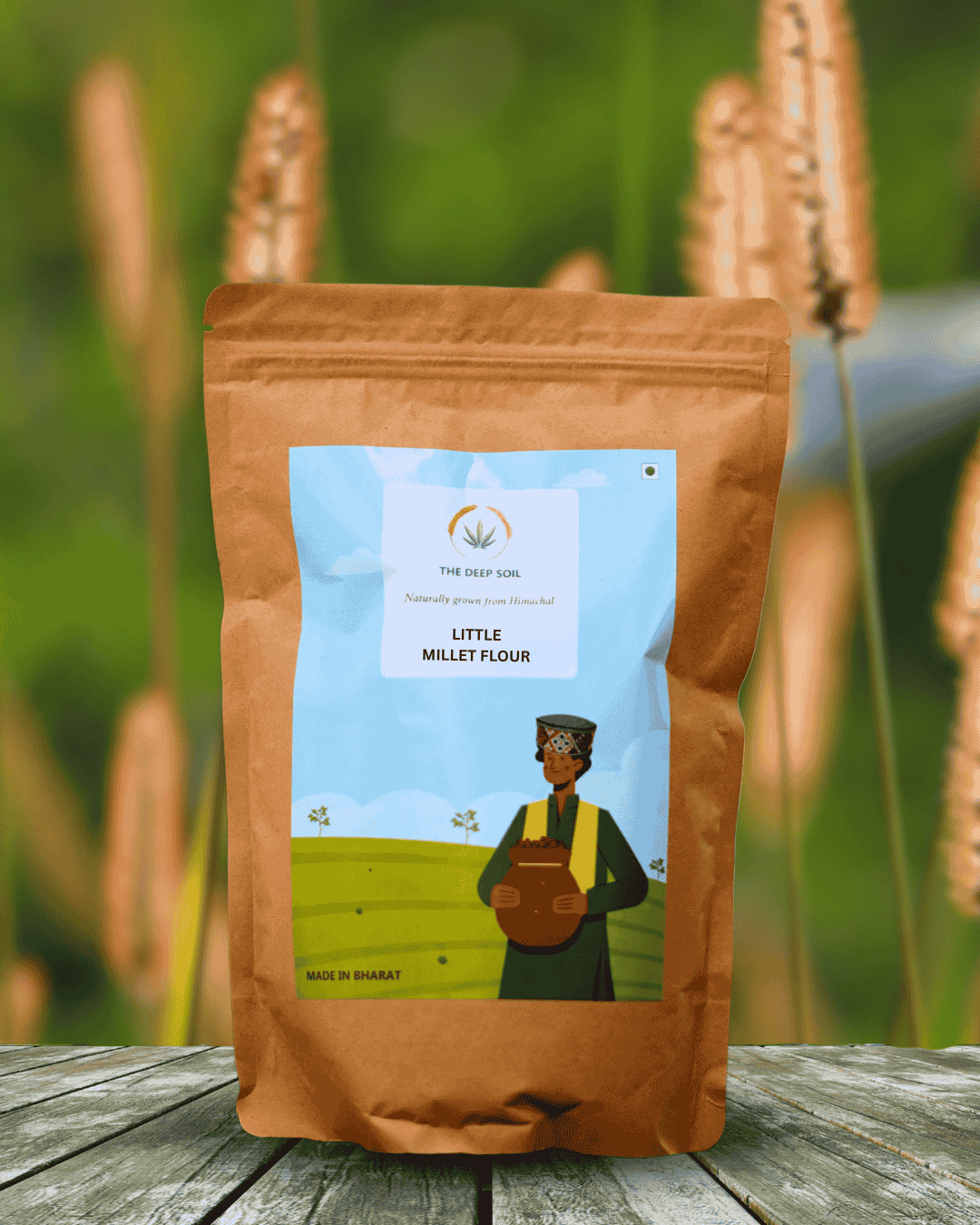 The Deep Soil Little Millet Flour Himachal Origin Field Background The Deep Soil Little Millet Flour package on wooden table with tall golden millet stalks background