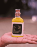 Hand holding The Deep Soil Cold-Pressed Almond Oil bottle showing Nutritive Value back label