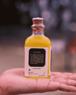 Hand holding The Deep Soil Cold-Pressed Oil bottle showing Our Story back label with brand history