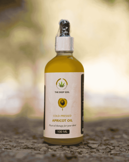 100ml bottle of The Deep Soil Cold-Pressed Apricot Oil on a stone surface with nature background