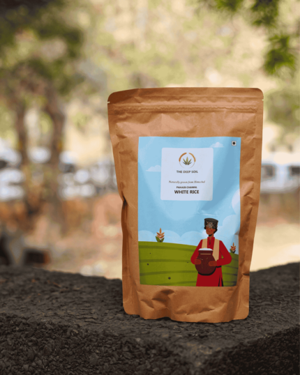 The Deep Soil Pahadi White Rice brown paper package on a stone surface with nature background